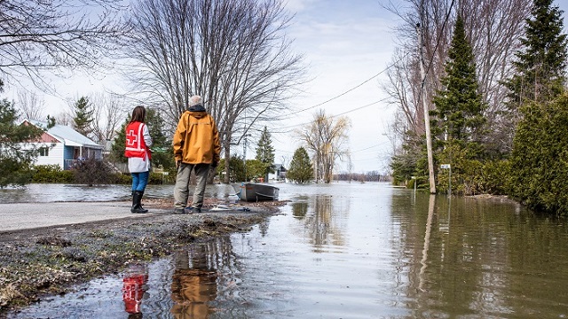 Two people look over a flooded street