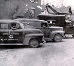 Three Red Cross cars aligned on the street during the Second World War