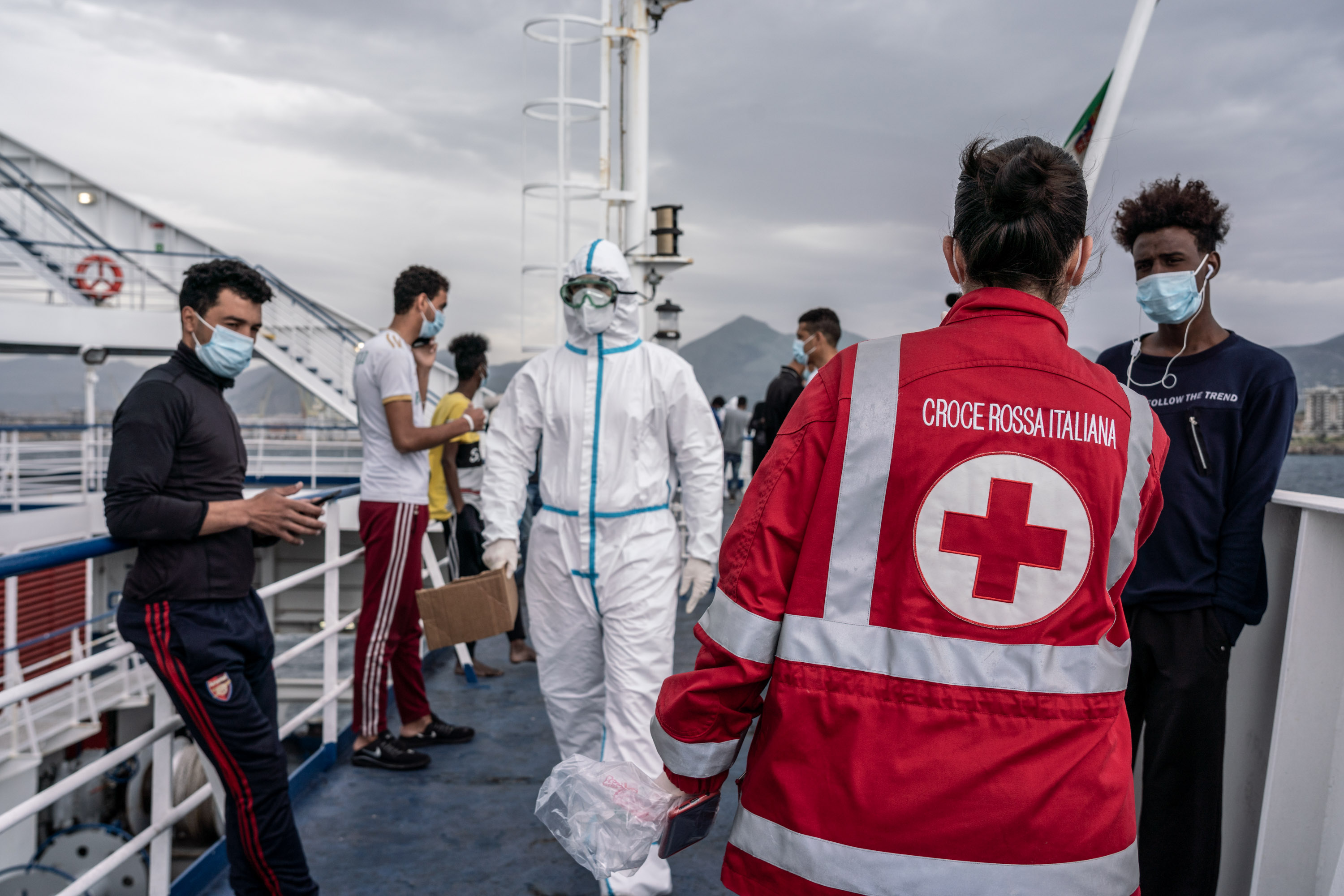 A group of people on a boat with Red Cross personnel